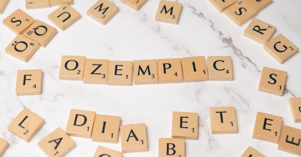 Scrabble tiles spelling Ozempic and diabetes on a marble surface.
