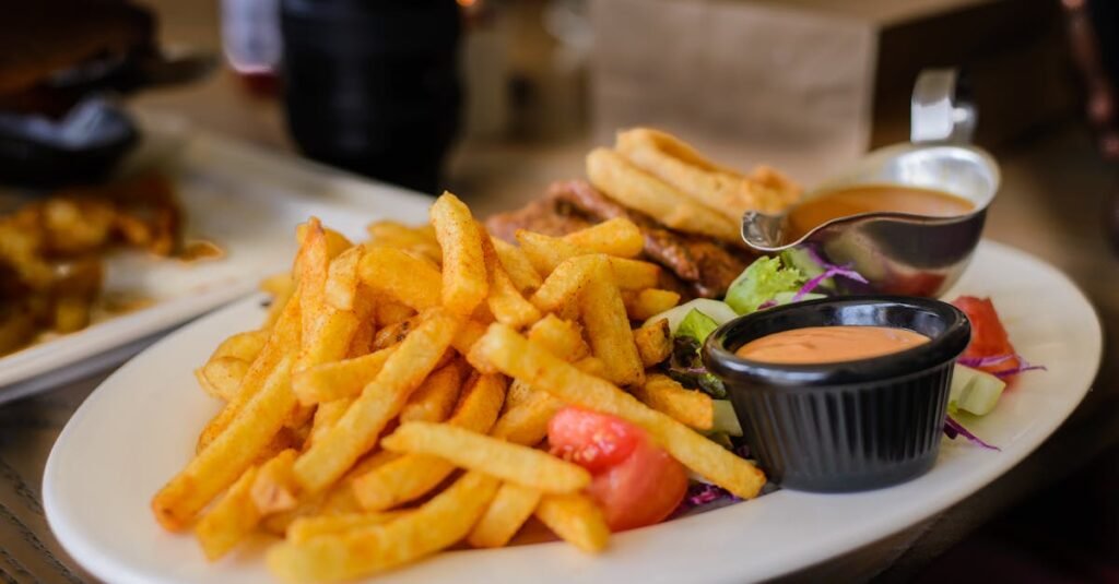 Delicious plate of golden french fries with dipping sauces, perfect for a satisfying meal.
